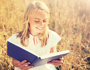 Image showing smiling young woman reading book on cereal field