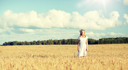 Image showing happy young woman in flower wreath on cereal field