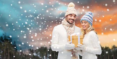 Image showing smiling couple in winter clothes with gift box