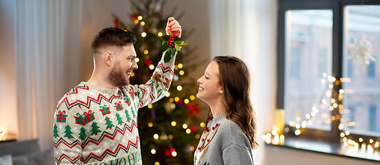 Image showing happy couple with mistletoe on christmas at home