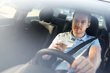 Image showing tired man driving car with takeaway coffee