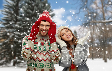 Image showing happy couple in ugly christmas sweaters in winter