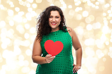 Image showing happy woman holding red heart over lights