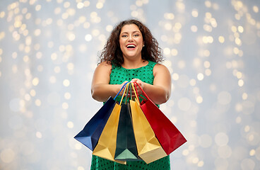 Image showing happy woman with shopping bags over lights