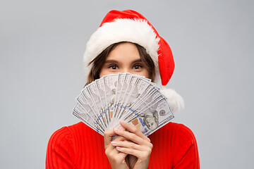 Image showing happy woman in santa hat with money on christmas