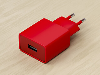 Image showing Red power adapter on wood background