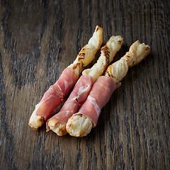 Image showing bread sticks with prosciutto