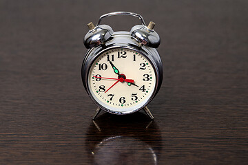 Image showing Metal alarm clock on a wooden table