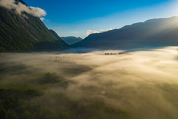 Image showing Morning mist over the valley among the mountains in the sunlight