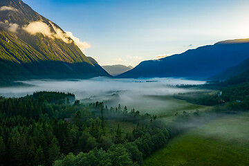 Image showing Morning mist over the valley among the mountains in the sunlight