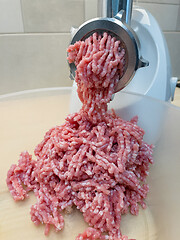 Image showing Meat grinder grinds pork meat