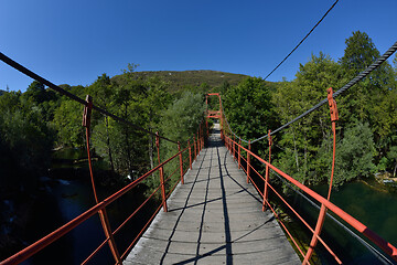 Image showing wooden bridge over wild river