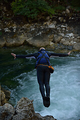 Image showing Man jumping in wild river