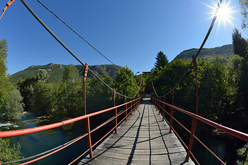 Image showing wooden bridge over wild river