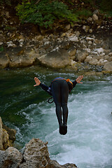 Image showing Man jumping in wild river