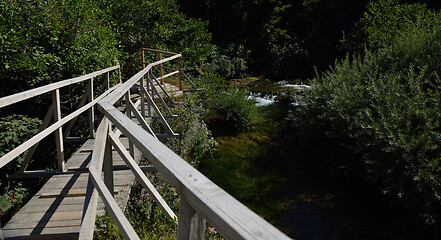 Image showing wooden bridge over wild river