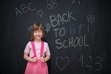 Image showing school girl child with backpack writing  chalkboard