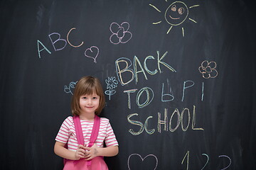 Image showing school girl child with backpack writing  chalkboard