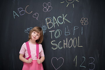 Image showing school girl child with backpack writing  chalkboard