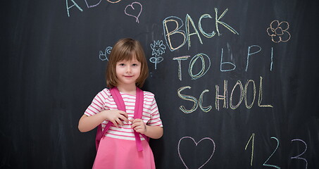 Image showing school girl child with backpack writing  chalkboard