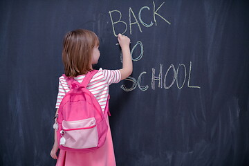 Image showing school girl child with backpack writing  chalkboard