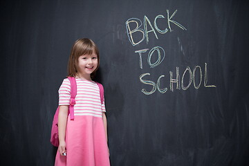 Image showing school girl child with backpack writing  chalkboard