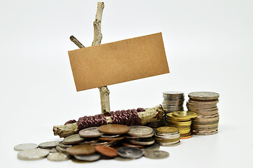 Image showing Paper sign board with stack of coins