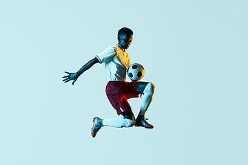 Image showing Male soccer player kicking ball in jump isolated on gradient background