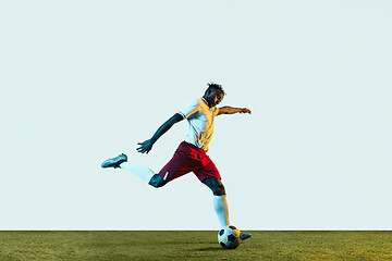 Image showing Male soccer player kicking ball isolated on white background