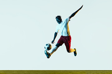 Image showing Male soccer player kicking ball isolated on white background