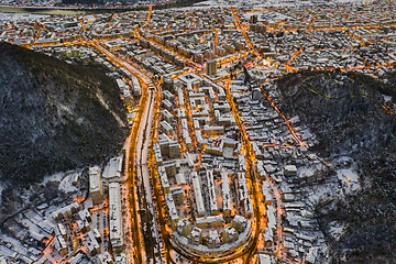 Image showing Aerial view of city and mountain behind at dusk