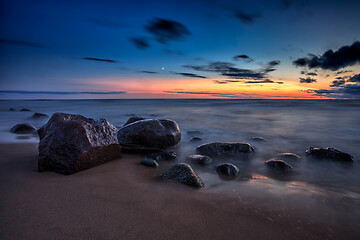 Image showing Sea sunset seascape with wet rocks