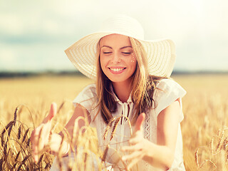 Image showing happy young woman in sun hat on cereal field