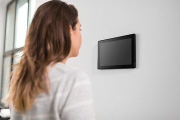 Image showing woman looking at tablet computer at smart home