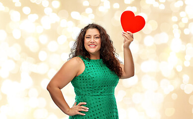 Image showing happy woman holding red heart over lights