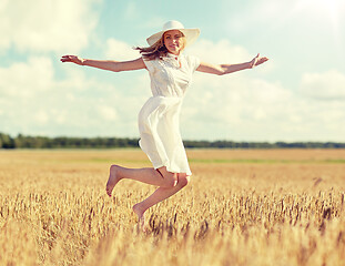 Image showing happy young woman jumping on cereal field