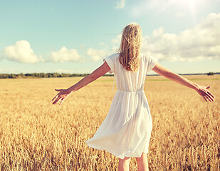 Image showing happy young woman in white dress on cereal field