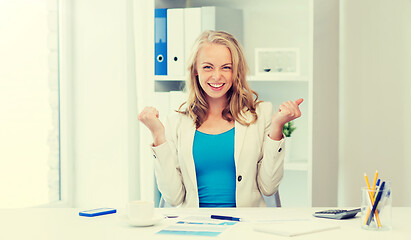 Image showing happy businesswoman celebrating success at office