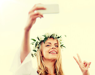 Image showing woman taking smartphone selfie and showing peace