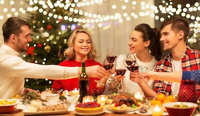 Image showing happy friends drinking red wine at christmas party