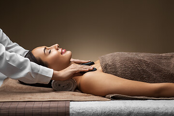 Image showing beautiful woman having hot stone massage at spa