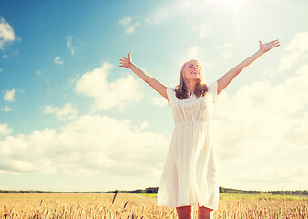 Image showing smiling young woman in white dress on cereal field