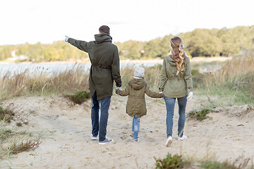 Image showing happy family walking along autumn beach