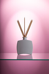 Image showing Aromatic reed air freshener on the glass table 