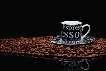 Image showing Coffee mug on a pile of coffee beans 