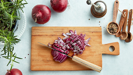 Image showing chopped red onions on wooden cutting board