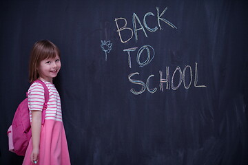 Image showing school girl child with backpack writing  chalkboard