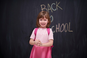 Image showing school girl child with backpack writing  chalkboard