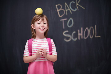 Image showing child holding apple on head