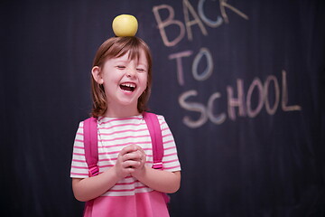 Image showing child holding apple on head